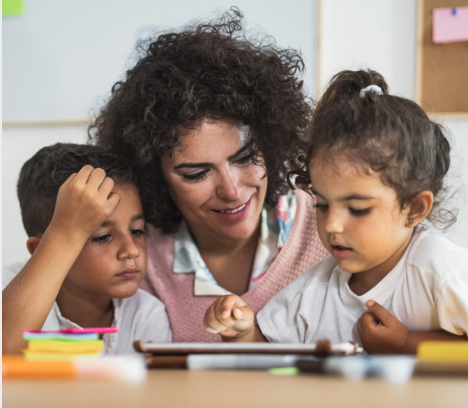 mom and children reading an ipad