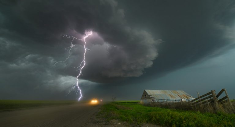 lightning striking a field near a barn
